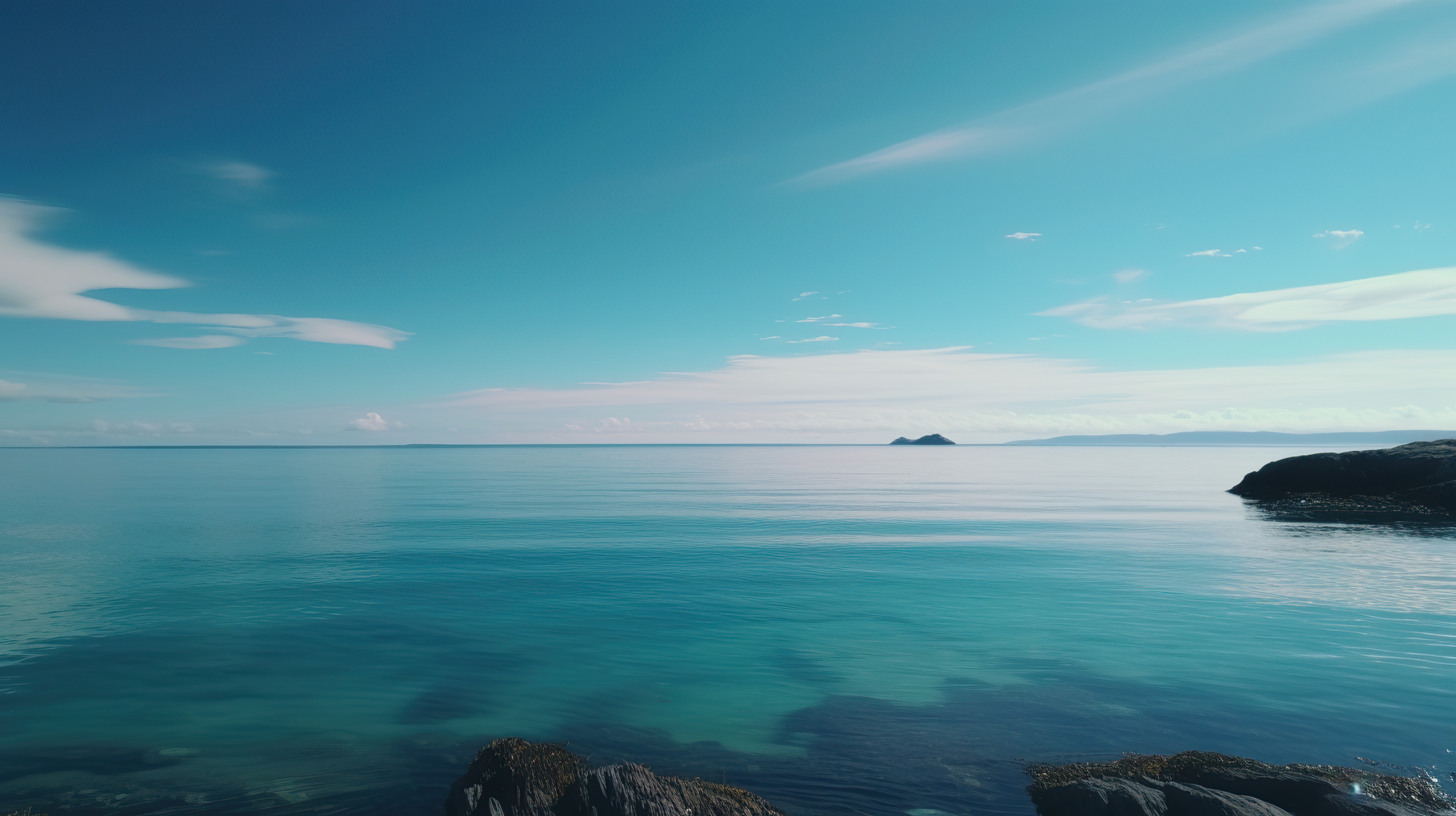Beautiful blue sky and a beach with clear blue water and rocks on the shore