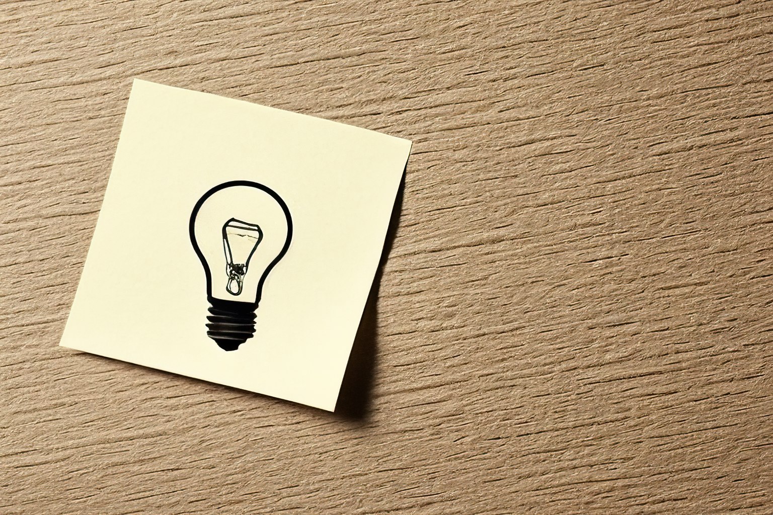 Light bulb idea symbol on yellow sticky note