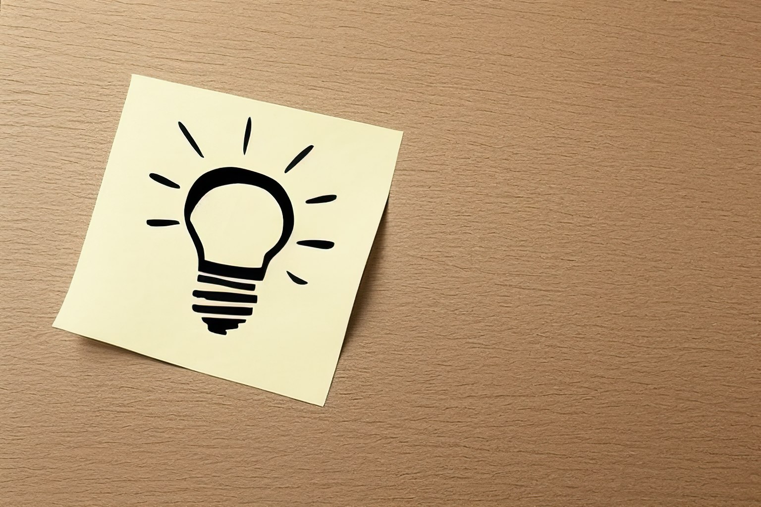 Light bulb idea symbol on yellow sticky note